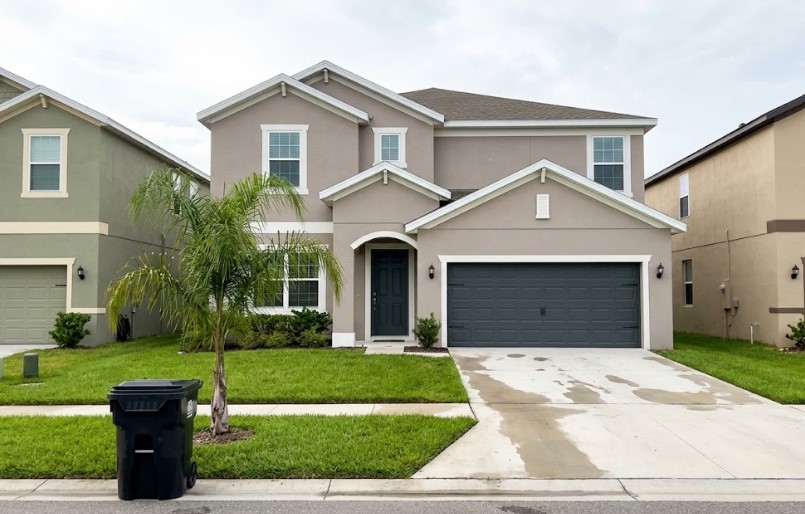 Peach Painting - Commercial vs Residential Painting in Tampa: Same Paint, New Rules Freshly painted two-story stucco home with a dark gray garage door in an HOA community